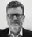 A man wearing glasses and a black jacket. Description generated by AI