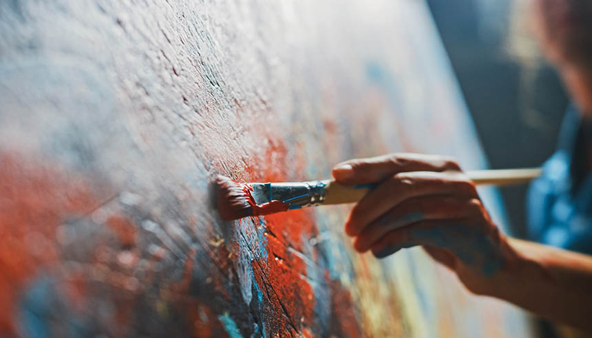 A person is painting a picture with a brush. Description generated by AI