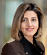 A woman wearing a brown jacket and black shirt. Description generated by AI