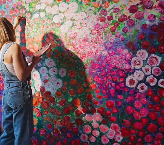 A woman is painting a picture of flowers. Description generated by AI