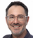 A man wearing glasses and a blue shirt. Description generated by AI