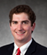 A man wearing a suit and tie with a red tie. Description generated by AI