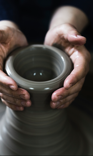 A person is holding a clay pot. Description generated by AI