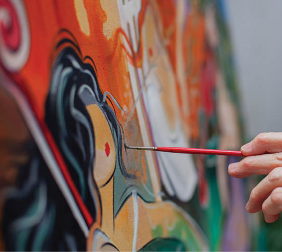 A person is painting a picture with a red brush. Description generated by AI