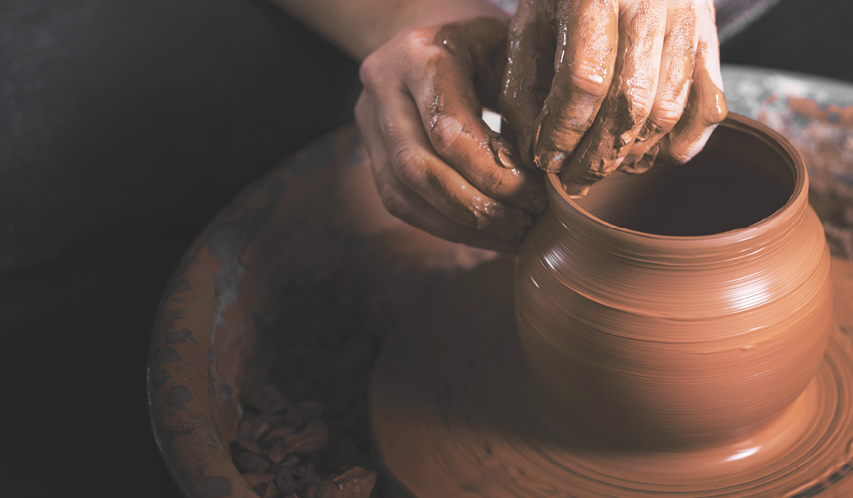 A person is making a pot with brown clay. Description generated by AI