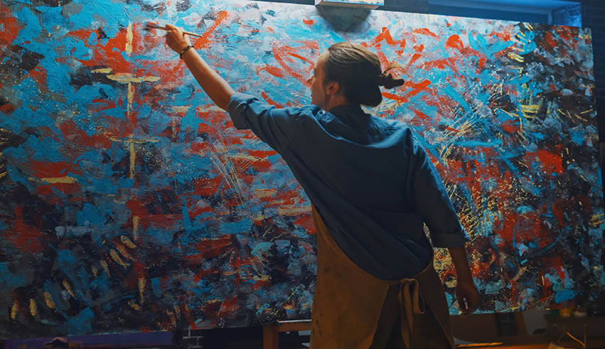 A man is painting a picture on a canvas. Description generated by AI