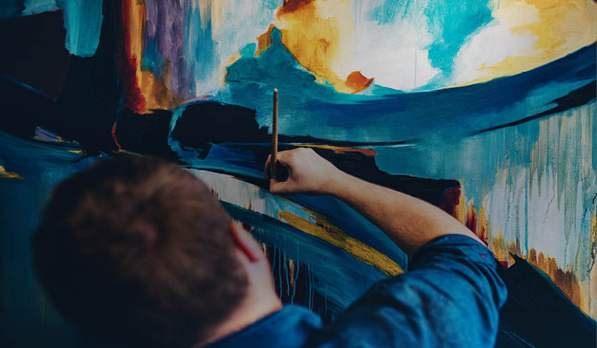 A man is painting a picture with a brush. Description generated by AI